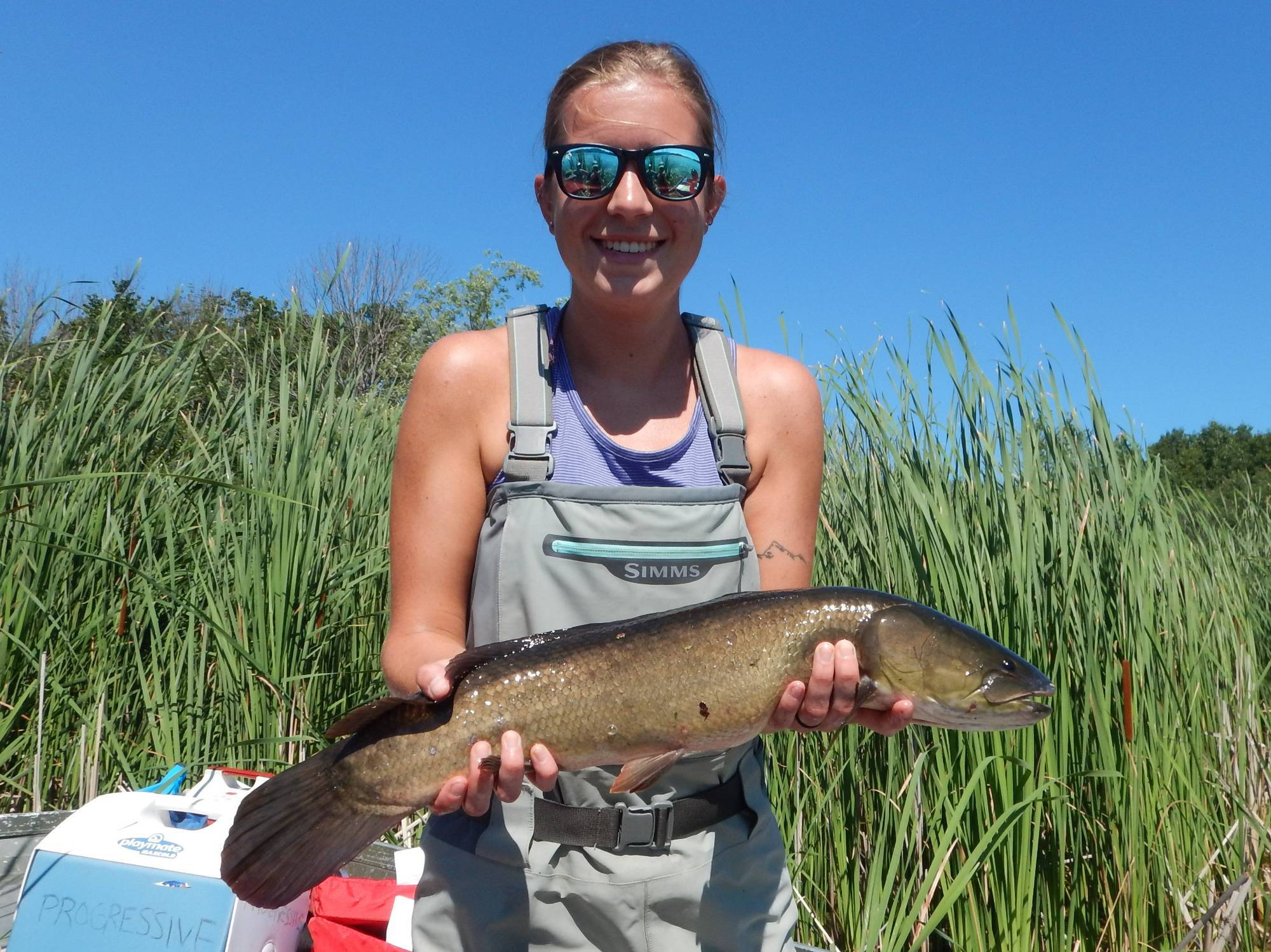 Kaitlyn holds a bowfin for the camera.